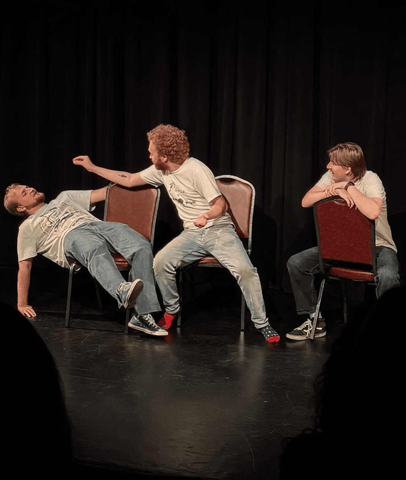 Performers acting on stage during improv scene