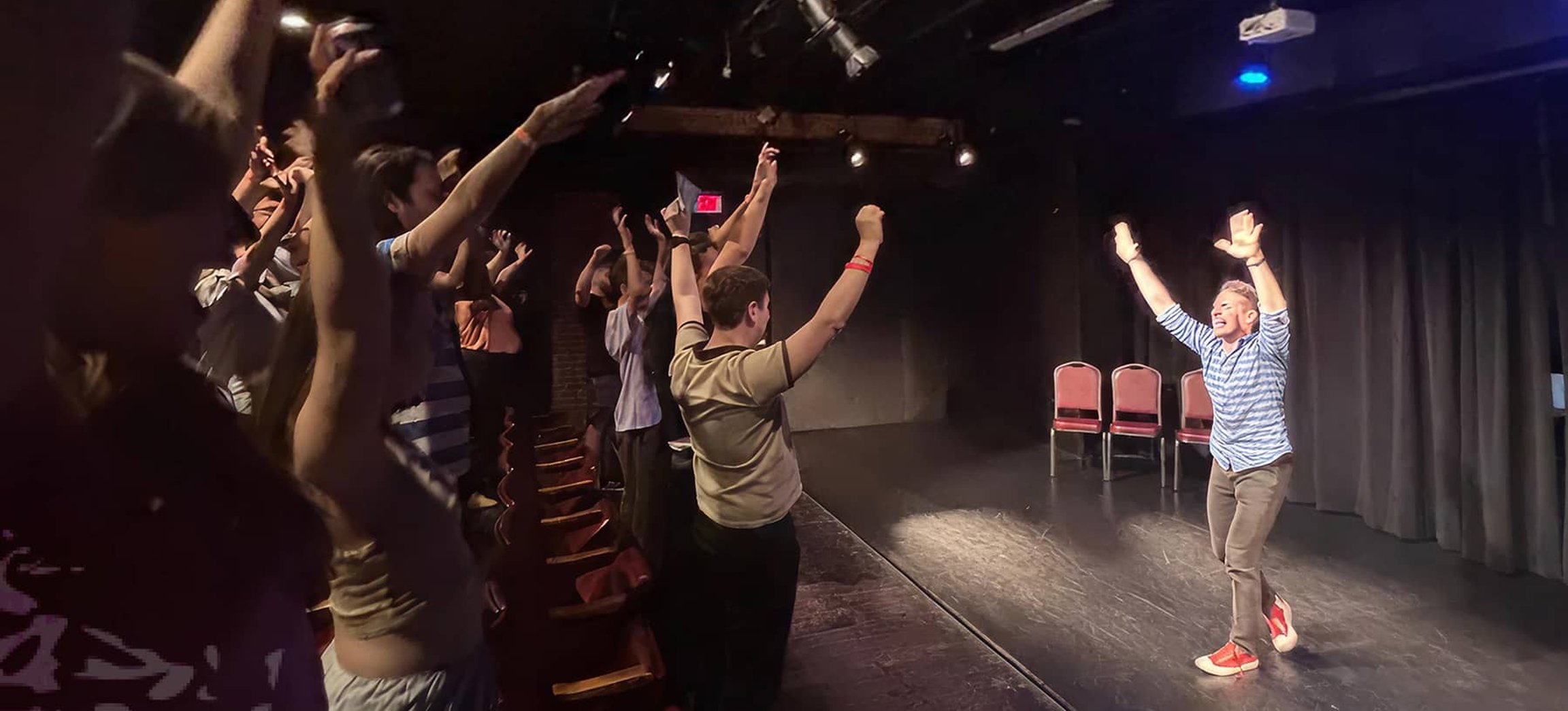 Improv performers taking a bow on stage