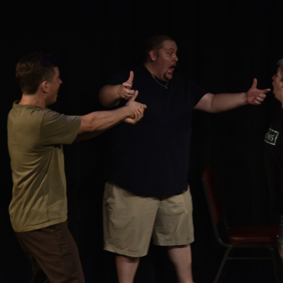 Three performers pointing across the stage at YAIF 2026