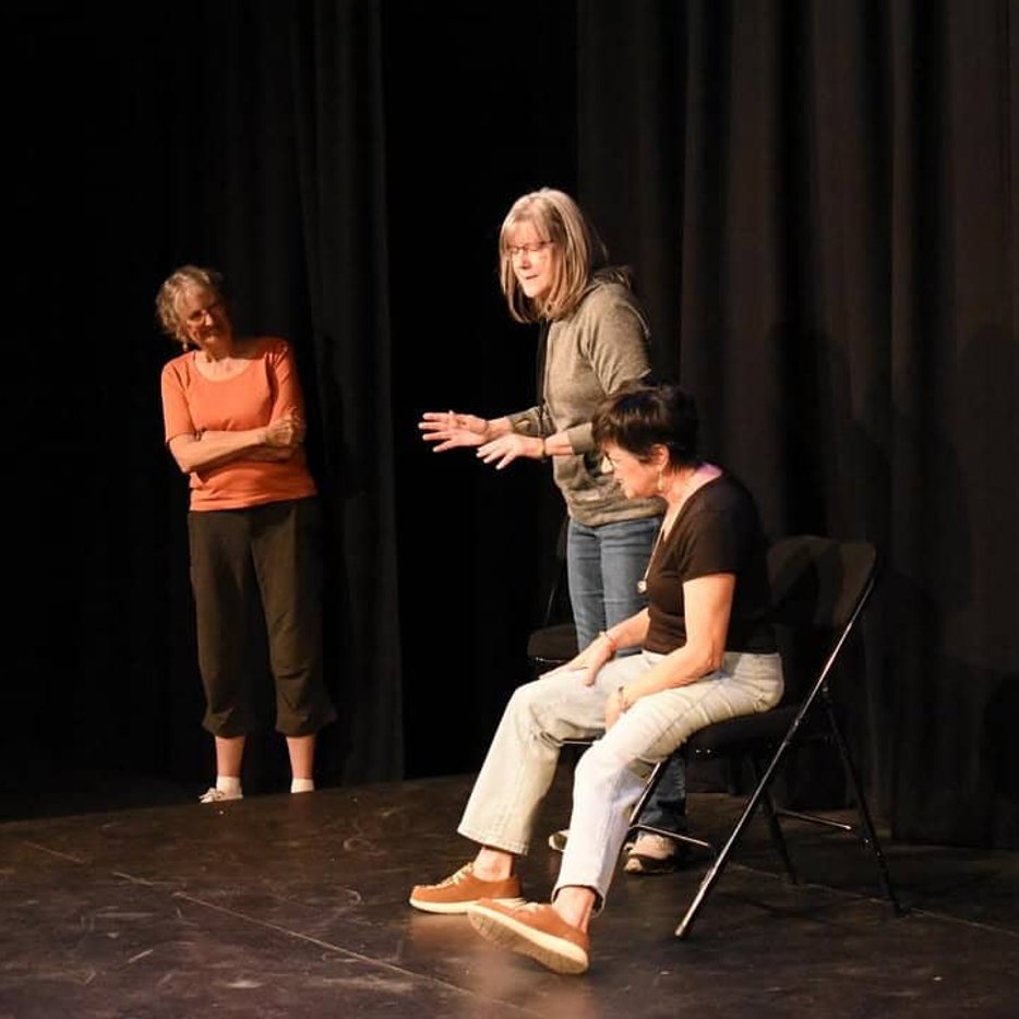 Actors performing on stage chairs